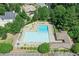 Aerial view of the community pool area with lounge chairs and manicured landscaping and nearby parking at 7015 Polo Dr, Cumming, GA 30040