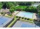 Aerial view of the community pool, tennis courts, and surrounding lush greenery and trees at 7015 Polo Dr, Cumming, GA 30040