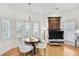 Cozy dining area featuring a round table, chandelier lighting, and plantation shutters for natural light control at 7015 Polo Dr, Cumming, GA 30040