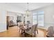 Formal dining room with wainscoting, stylish chandelier, and access to multiple living areas and natural light at 7015 Polo Dr, Cumming, GA 30040