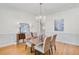 Well-lit dining room features hardwood floors, wainscoting, and a modern chandelier at 7015 Polo Dr, Cumming, GA 30040