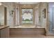 A soaking tub sits below a stained glass window inside this large primary bath with tiled shower and separate vanities at 870 Waddington Ct, Atlanta, GA 30350