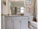 Well-lit bathroom showcasing a vanity with modern countertop, framed mirror and patterned wall paper at 870 Waddington Ct, Atlanta, GA 30350