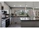 Modern kitchen featuring sleek gray cabinets, black countertops and appliances, and recessed lighting at 870 Waddington Ct, Atlanta, GA 30350