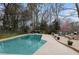 Backyard pool area with a deck, lush greenery, and space for outdoor dining at 870 Waddington Ct, Atlanta, GA 30350