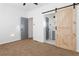 Spacious bedroom features neutral carpet, a stylish barn door, and ensuite bathroom access at 994 Byron Sw Dr, Atlanta, GA 30310