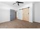 Spacious bedroom features neutral carpet, a stylish barn door, and ensuite bathroom access at 994 Byron Sw Dr, Atlanta, GA 30310