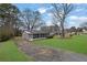 Exterior view of a home with a screened-in porch, complemented by a green lawn and mature trees at 2880 Hall Se Dr, Smyrna, GA 30082