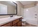 Bathroom with a single sink vanity with wood cabinets, mirror and shower-tub combo at 312 Overview Dr, Canton, GA 30114
