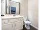 Neat half bathroom features a vanity, framed mirror, and toilet against a neutral wall at 312 Overview Dr, Canton, GA 30114