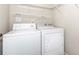 Functional laundry room with a white washer and dryer and wire shelving for storage at 312 Overview Dr, Canton, GA 30114