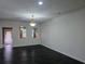 Bright and airy living room with neutral walls, dark floors, and natural light from windows and a glass door at 312 Overview Dr, Canton, GA 30114