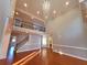 Elegant living room with hardwood floors, tall windows, soaring ceiling, and an open view of the upper floor at 505 Tilbury Dr, Suwanee, GA 30024