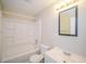 Clean bathroom with a shower-tub combination, white vanity, and modern light fixture at 5411 Louis Xiv Ln, Atlanta, GA 30349