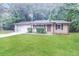 Well-maintained single-story brick home with an attached garage and a lush green lawn at 5411 Louis Xiv Ln, Atlanta, GA 30349