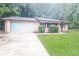 Charming single-story brick home boasting an attached garage and a sprawling front lawn at 5411 Louis Xiv Ln, Atlanta, GA 30349