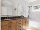 Stylish bathroom features a wood vanity with double sinks, black countertops, and sleek, modern fixtures at 1563 Westwood Sw Ave, Atlanta, GA 30310