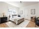 Bright bedroom features hardwood floors, neutral decor, and a cozy armchair at 1563 Westwood Sw Ave, Atlanta, GA 30310