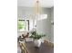 Light-filled dining room featuring a decorative chandelier and a table setting with seating, with a view into the living room at 1563 Westwood Sw Ave, Atlanta, GA 30310