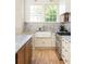 Farmhouse sink is centered between two windows with marble backsplash and countertops and stainless steel oven at 1563 Westwood Sw Ave, Atlanta, GA 30310