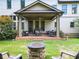 Beautiful backyard featuring a stone fire pit, manicured lawn, and a covered patio at 201 Beacon Cv, Canton, GA 30114