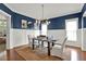 Stylish dining room featuring dark blue walls, white wainscoting, and modern lighting at 201 Beacon Cv, Canton, GA 30114