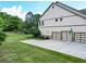 Well-manicured lawn leading to a three car garage and home exterior at 201 Beacon Cv, Canton, GA 30114