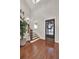 Bright foyer with hardwood floors, elegant staircase, and decorative door creating a welcoming entrance at 201 Beacon Cv, Canton, GA 30114