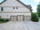 Three-car garage with neutral colored doors and concrete driveway at 201 Beacon Cv, Canton, GA 30114