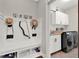 Mudroom with built-in bench, storage, and adjacent laundry area with modern machines at 201 Beacon Cv, Canton, GA 30114