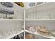 Organized pantry with an array of glassware, dishes and serving platters on white shelving at 201 Beacon Cv, Canton, GA 30114