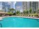 Beautiful pool with lounge chairs surrounded by lush greenery and modern high-rise buildings at 3445 Stratford Ne Rd # 2402, Atlanta, GA 30326