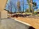 Back patio with a backyard that has pine straw and tall trees at 3850 Westwick Nw Way, Kennesaw, GA 30152