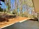 Back patio with a backyard that has pine straw and tall trees at 3850 Westwick Nw Way, Kennesaw, GA 30152