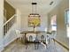 A cozy dining room features a table, chairs, a modern light fixture, and a staircase in the background at 3850 Westwick Nw Way, Kennesaw, GA 30152