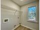 Functional laundry area with overhead wire rack and plenty of natural light from the window at 3850 Westwick Nw Way, Kennesaw, GA 30152