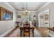 Spacious dining room featuring hardwood floors, a vintage chandelier, and natural light from the large windows at 3890 Irwin Bridge Nw Rd, Conyers, GA 30012