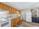 Kitchen with white appliances, wood cabinets, and a sink with natural light at 3890 Irwin Bridge Nw Rd, Conyers, GA 30012