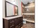 Well-lit bathroom with dark wood vanity, stone countertop, and a glass-enclosed shower with horizontal tiling at 4526 Warren Mill Trl, Ellenwood, GA 30294