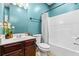 The bathroom has teal walls, a vanity with a dark wood finish, and a shower-tub combo with a white curtain at 4526 Warren Mill Trl, Ellenwood, GA 30294