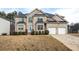 Charming two-story brick home with well-manicured landscaping, attached two-car garage, and inviting front entrance at 4526 Warren Mill Trl, Ellenwood, GA 30294