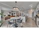 Open concept kitchen with stainless appliances flows into the living room with a fireplace and a statement chandelier at 213 Augusta Walk, Canton, GA 30114