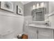 Elegant powder room with wainscoting, marble countertop, decorative mirror, and stylish decor at 2384 Defoors Ferry Nw Rd, Atlanta, GA 30318