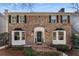 Classic brick home with bay windows, black shutters, and an inviting front entrance at 2384 Defoors Ferry Nw Rd, Atlanta, GA 30318