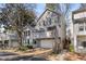 Stylish gray townhome featuring a balcony, a two-car garage, and landscaped surroundings, creating a modern aesthetic at 2384 Defoors Ferry Nw Rd, Atlanta, GA 30318