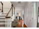 Bright foyer with wooden staircase, hardwood floors, white walls, and decorative furniture at 2384 Defoors Ferry Nw Rd, Atlanta, GA 30318