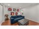 Relaxing living room with a blue couch, ottoman, hardwood floors, and sports memorabilia on the walls at 2384 Defoors Ferry Nw Rd, Atlanta, GA 30318