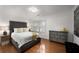 This bedroom features a grey upholstered bed and hardwood floors at 2384 Defoors Ferry Nw Rd, Atlanta, GA 30318