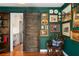 Office space showcasing a dark barn door, hardwood floors, green walls, and decorative wall art at 2384 Defoors Ferry Nw Rd, Atlanta, GA 30318