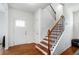 Inviting foyer with hardwood floors, featuring a staircase with wooden banister and a front door with transom window at 855 Venture Sw Way, Atlanta, GA 30331